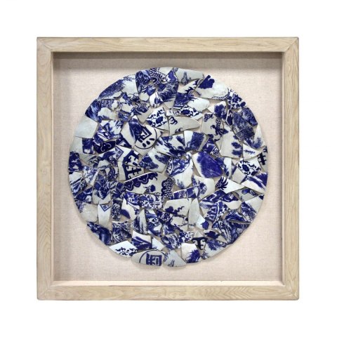 Okrąg z niebieskiej i białej porcelany w ramce na bawełnianym tle